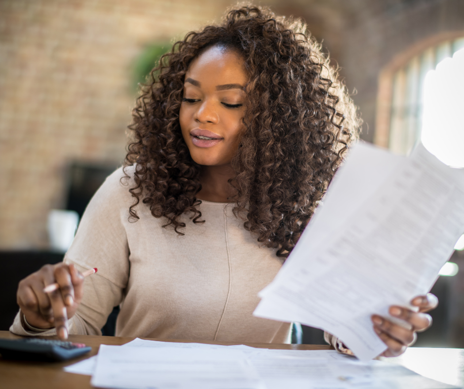 An image of a woman looking at her finances and looking confident, demonstrating that it's very important to know how financial stress affects women's health. 